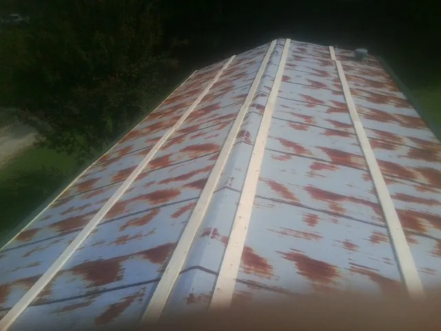 Rusted metal roof panels with new wood purlins before replacement — Storm Damage Roof Repair in Clarkson by Roofing Brothers